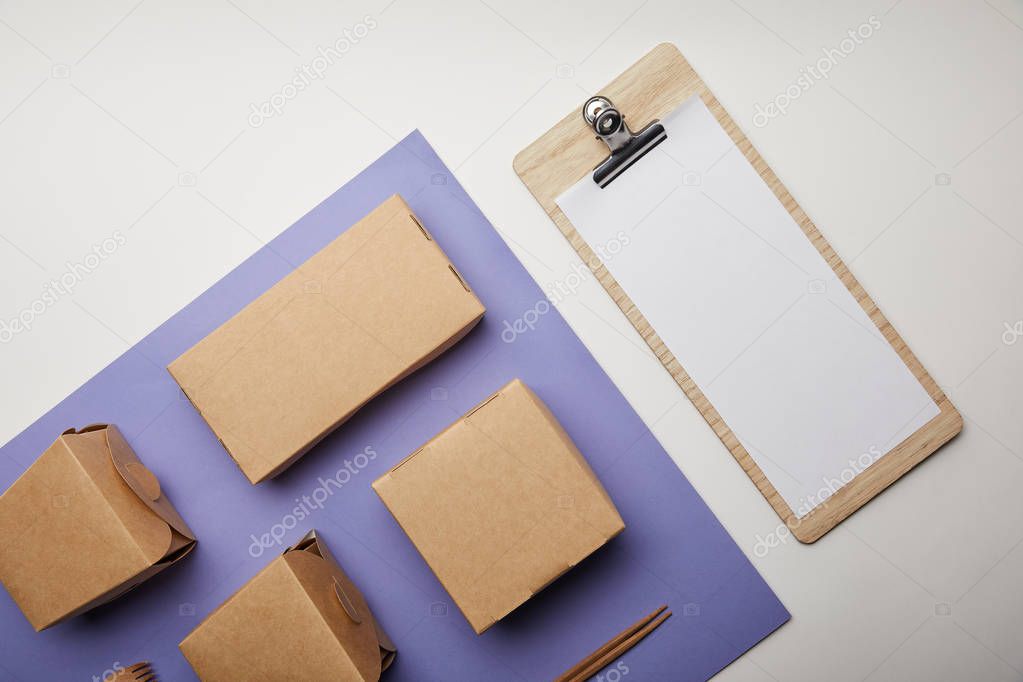 top view of noodle boxes, chopsticks and food boxes and menu on surface 