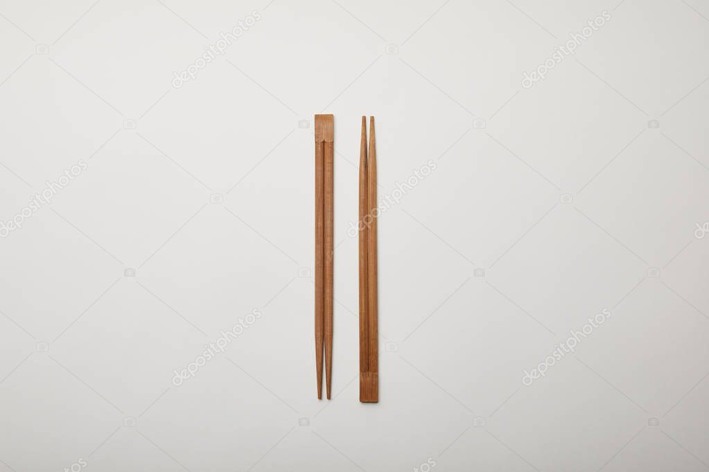 top view of arranged chopsticks on white surface, minimalistic concept 