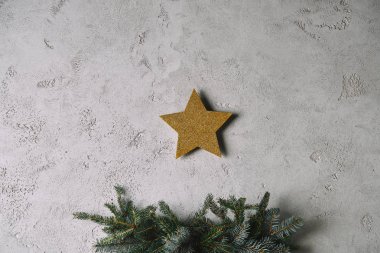 Gri duvar odadaki Noel ağacı yukarıda asılı Noel altın yıldız