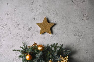 Gri duvar odadaki Noel ağacı yukarıda asılı Noel altın yıldız