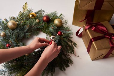 kadının üzerinde beyaz izole Noel topları ile köknar çelenk dekorasyon kırpılmış görüntü