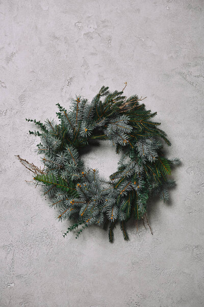 fir wreath for Christmas decoration hanging on grey wall in room