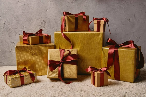 Σωρός Από Χρυσή Κουτιά Δώρου Χριστουγέννων Στον Τάπητα Δωμάτιο — Φωτογραφία Αρχείου