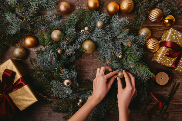 cropped image of woman making christmas decoration at wooden table