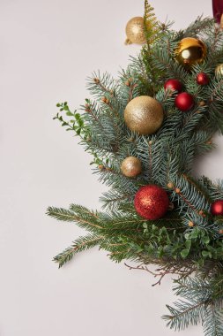 Noel köknar çelenk üzerinde beyaz izole kırmızı ve altın baubles ile üstten görünüm