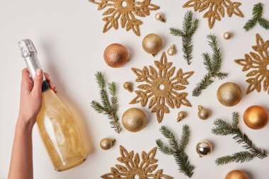 bir Noel dekorasyonu üzerine beyaz izole yakınındaki köpüklü şampanya tutan kadın kırpılmış görüntü
