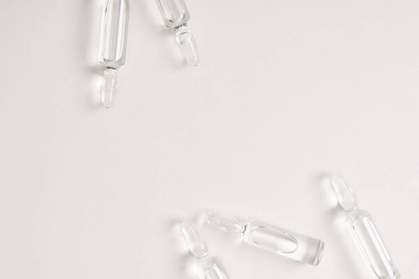 elevated view of ampoules with medical liquid on white surface 