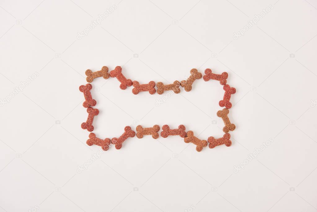 top view of bone made of dog food on white surface