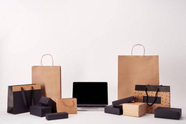 Laptop ile alışveriş torbaları ve kutuları beyaz yüzeyi ile boş ekran siyah Cuma kavramı