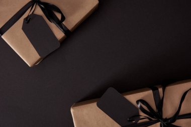 üstten görünüm Craft hediyeler siyah etiketleri ile siyah yüzey, siyah Cuma konsepti üzerine sarılmış.