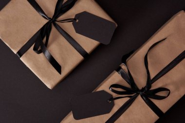 üstten görünüm Craft hediye kutuları siyah yüzey, siyah Cuma kavramı üzerinde siyah etiketleri ile sarılmış