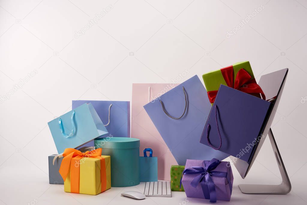 side view of colorful boxes with bags going out of computer screen, black friday concept