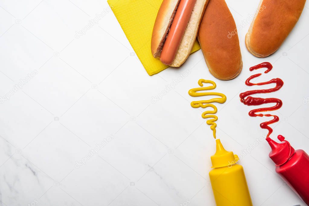 top view of tasty hot dog with mustard and ketchup on white marble surface