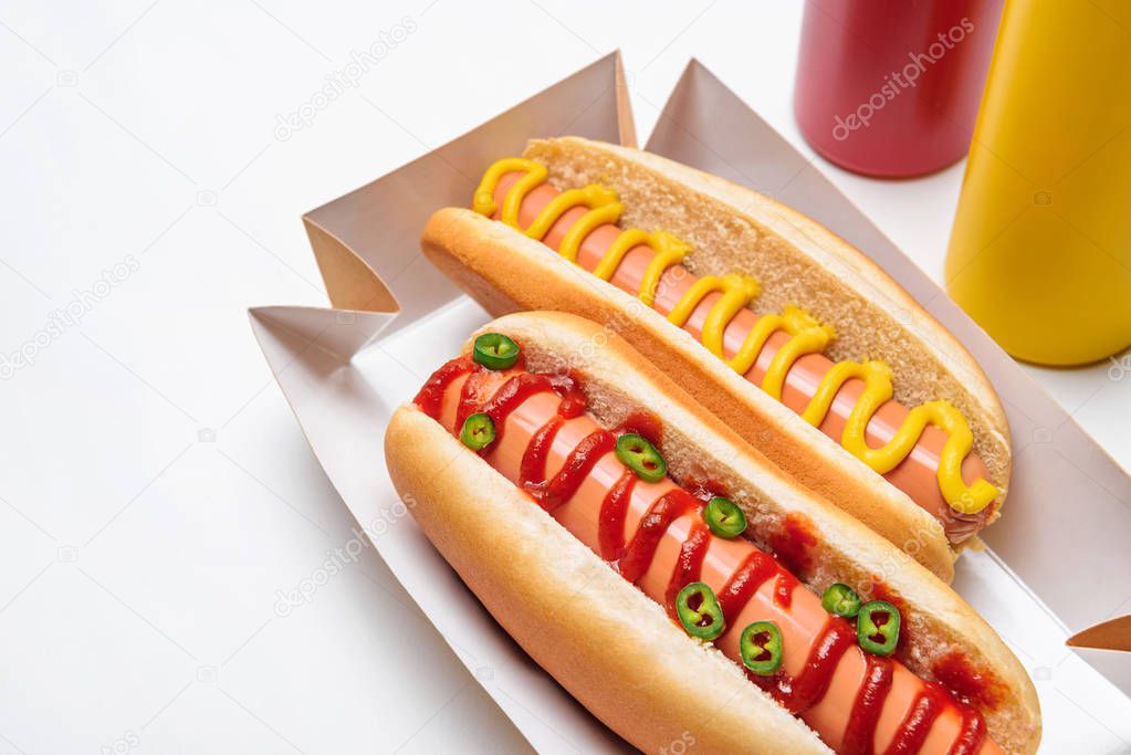 close-up shot of hot dogs with mustard and ketchup on white