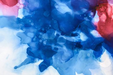 beautiful blue, red and violet splashes of alcohol inks as abstract background