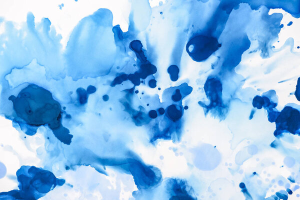 blue and light blue splashes of alcohol ink on white as abstract background