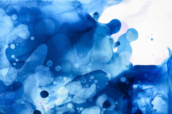 blue and violet splashes of alcohol inks as abstract background