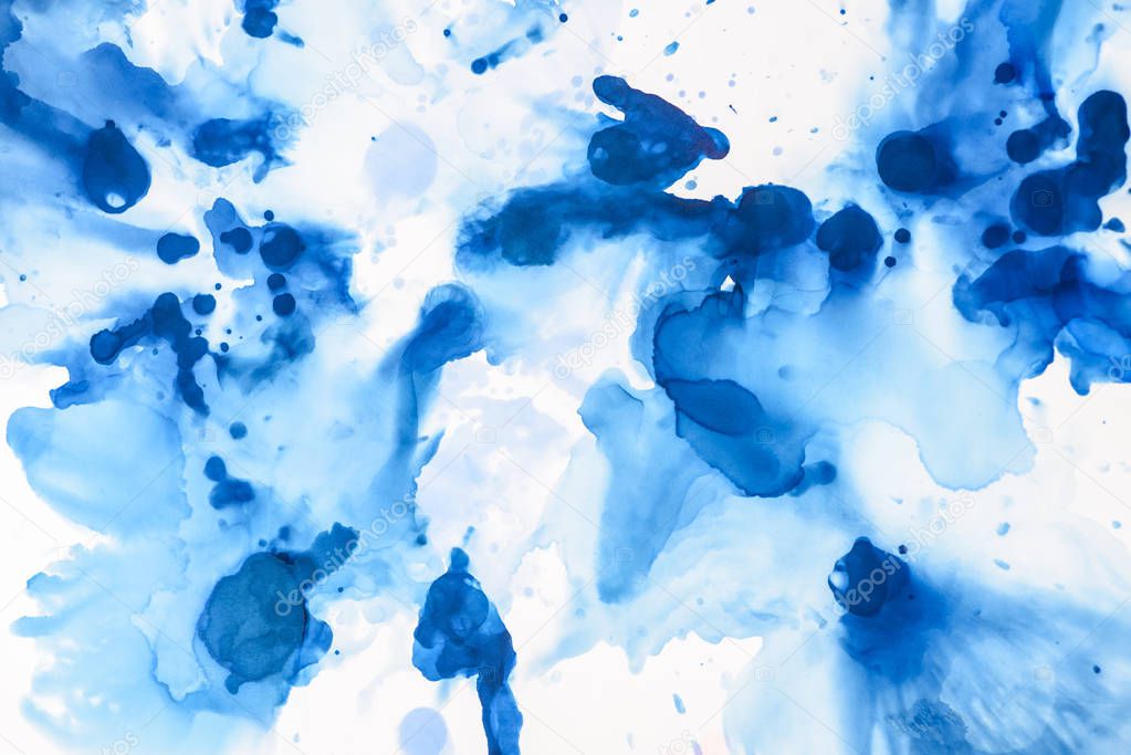 textured blue splashes of alcohol ink on white as abstract background