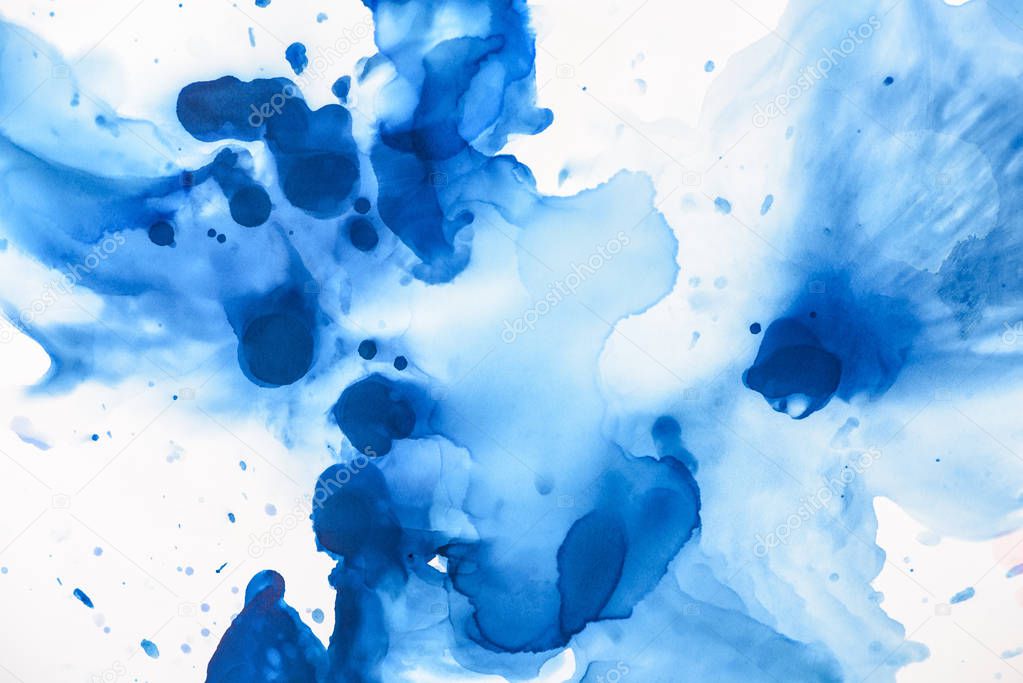 blue splashes of alcohol ink on white as abstract background