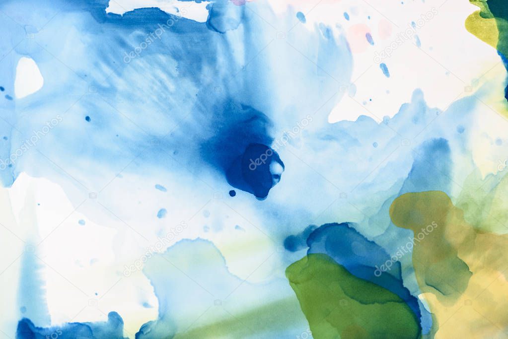 green and blue splashes of alcohol inks as abstract background