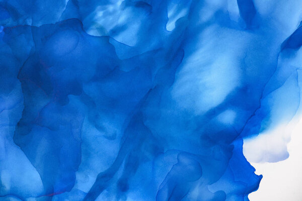 ярко-голубые брызги алкогольных чернил в качестве абстрактного фона
