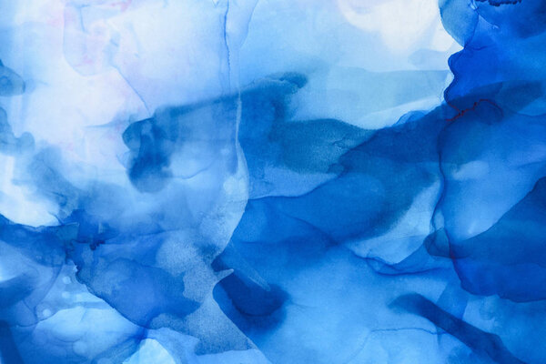 голубые и светло-голубые брызги алкогольных чернил в качестве абстрактного фона
