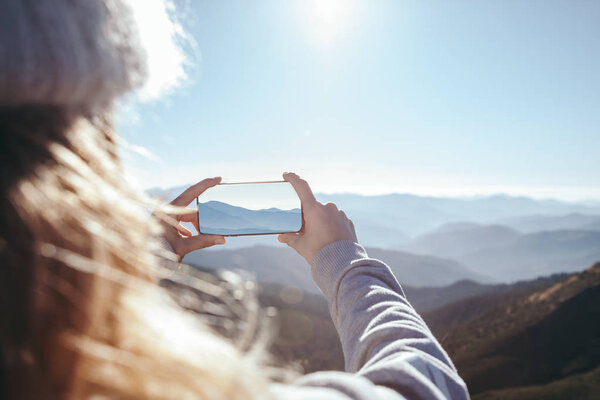 cropped shot of woman taking photo of mountain with smartphone, Carpathians, Ukraine