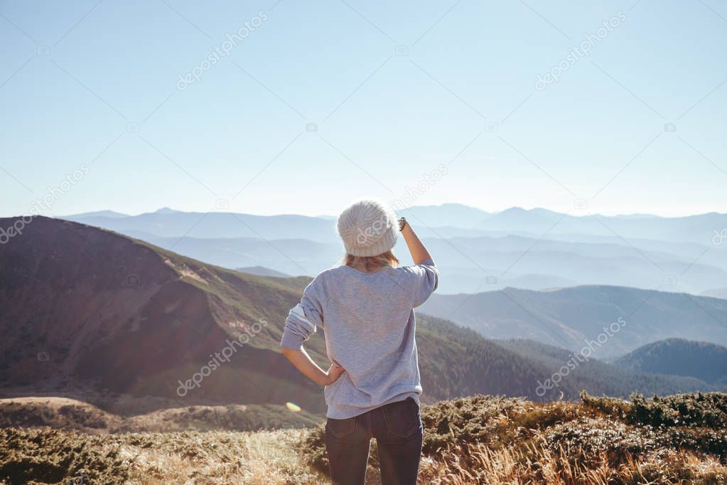rear view of female explorer looking at scenic mountains on sunny day, Carpathians, Ukraine
