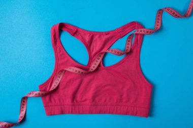 pembe spor sutyeni görünümünü yüksek de izole mavi, minimalist kavramı üzerinde bant ölçme 