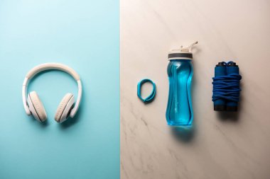 düz lay kulaklık, şişe su, ip atlama ve fitness izci mavi ve mermer ile