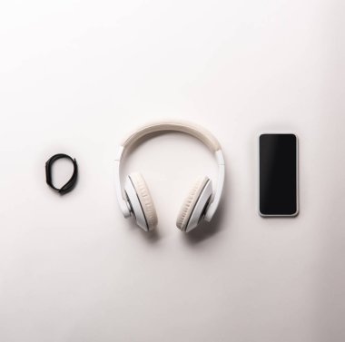 fitness izci, kulaklık ve smartphone ile boş perde üstten görünüm satır izole beyaz, minimalist kavramı üzerinde yerleştirilir 