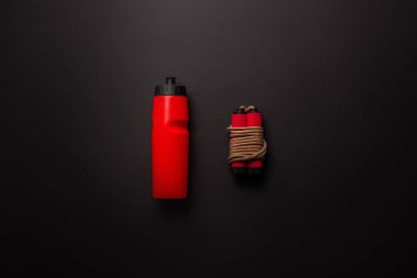 Kırmızı spor şişe ile yat ve izole siyah, minimalist kavramı üzerinde ip atlama 