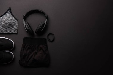 Düzenlenmiş spor giyim, kulaklık ve fitness izci siyah izole üstten görünüm