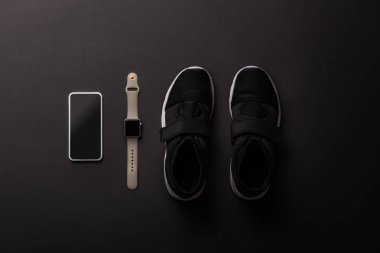boş ekran, smartwatch ve spor ayakkabı siyah izole görücü usulü smartphone'un yükseltilmiş görünümü