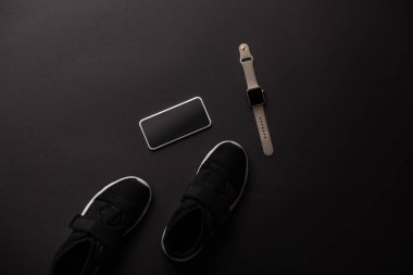 dan yukarıda smartphone, smartwatch ve spor ayakkabı siyah izole görüntülemek