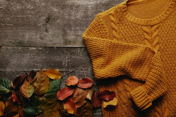 Flache Liege Mit Abgefallenen Blättern Und Orangefarbenem Pullover Auf Holztischplatte — Stockfoto