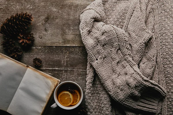 ウール セーター 木製の表面にお茶とパイン コーンのカップとフラット レイアウト — ストック写真