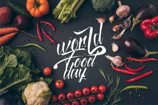 在灰色的桌子上 有世界食品日字母的未加工蔬菜的顶视图 — 图库照片