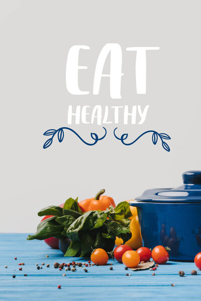 pan with ripe organic vegetables on table, eat healthy lettering