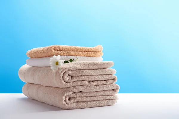Vergrote Weergave Van Gestapelde Schone Handdoeken Met Witte Kamille Bloem — Stockfoto