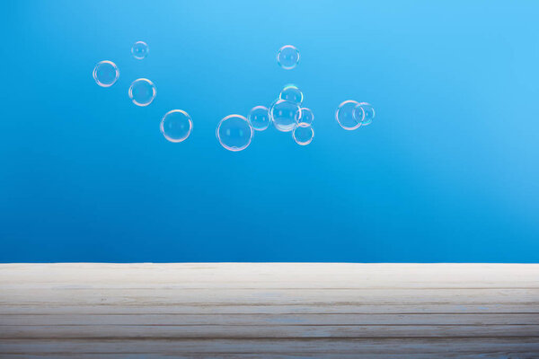 clean transparent soap bubbles on blue background 