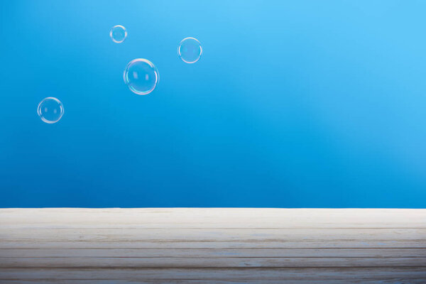 clean soap bubbles and white surface on blue background 