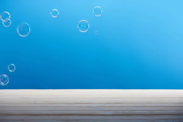 Seifenblasen Und Weiße Oberfläche Auf Blauem Hintergrund — Stockfoto