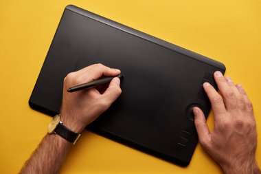 grafik tablet ile sarı yüzeyde çizim adamın kırpılmış atış