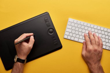 grafik tablet ve klavye ile tasarımcı çizim sarı yüzeyi görüntüsünü kırpılmış