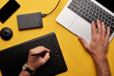 bir grafik tasarımcı çalışma laptop ve grafik tablet sarı yüzeyi ile kırpılmış atış