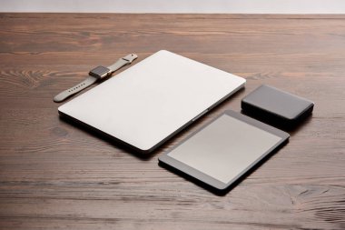 laptop tablet, akıllı izle ve ahşap masa üstünde taşınabilir hdd ile