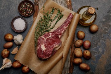 baharat, ot ve gri arka plan üzerinde patates ile kagit üzerinde ham kaburga eti