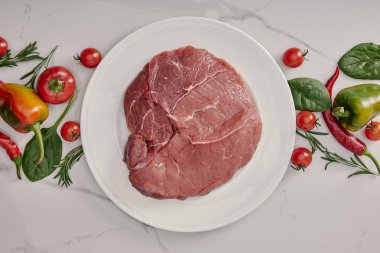 top view of fresh raw meat on plate with vegetables and herbs on white background clipart