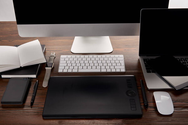 modern designer workplace with different gadgets on wooden table